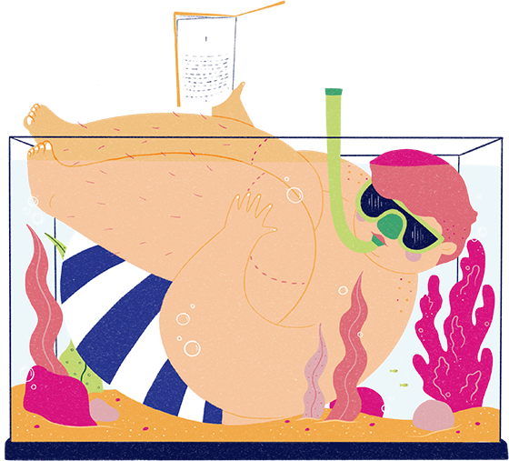 A young man in swim shorts and a snorkel sits squeezed into a fish tank holding a book out of the water with his right hand